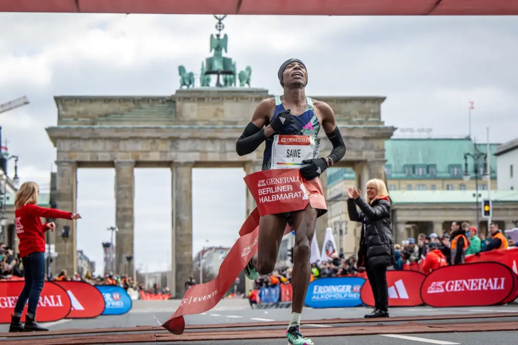 Berlin Marathon finish line under Brandenburg Gate with runners crossing
